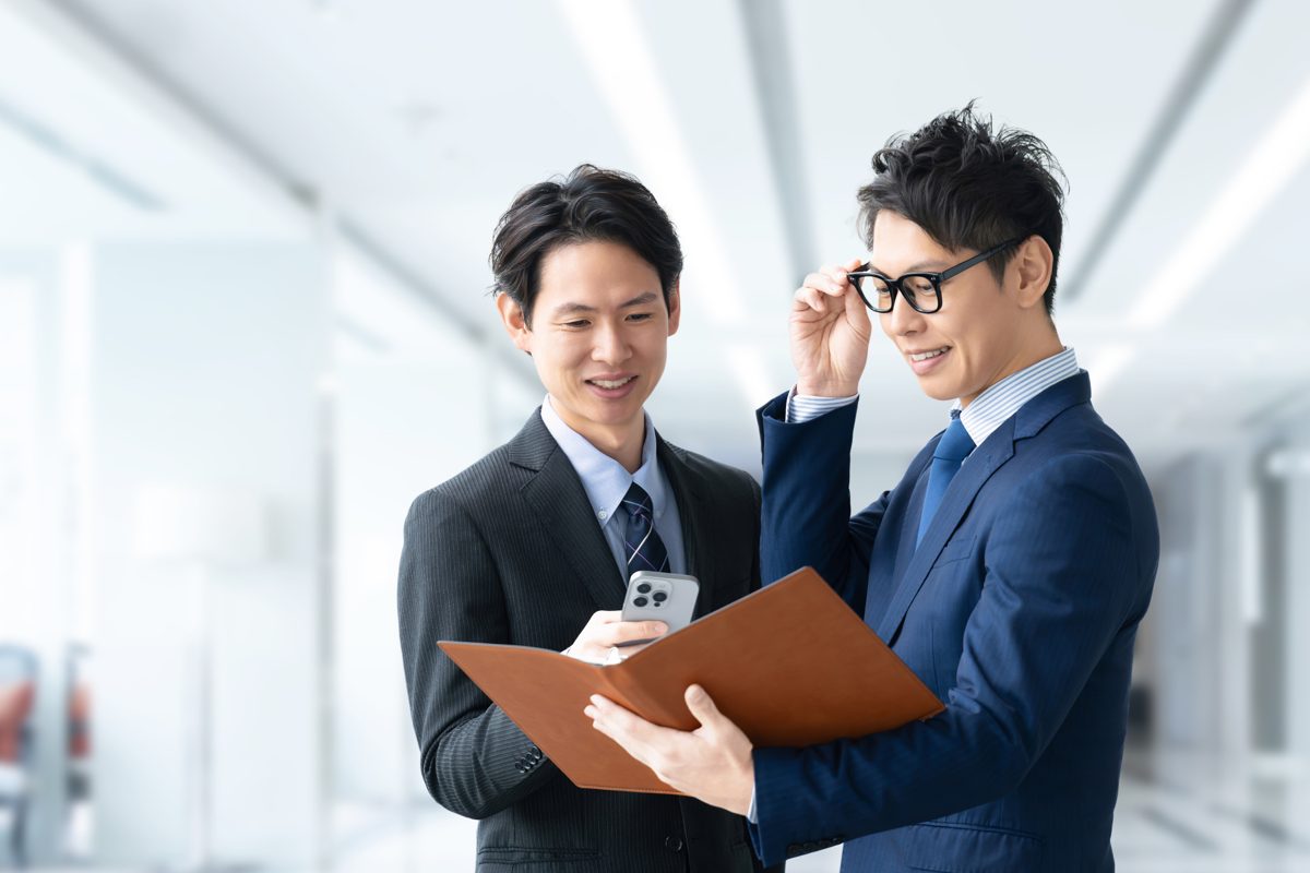 資料を見ながら打ち合わせをする二人